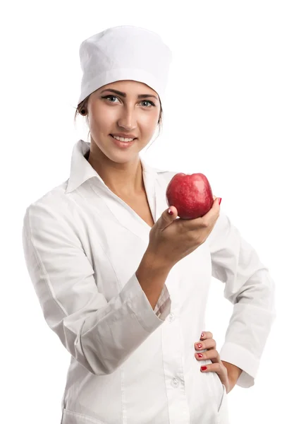 Smiling young doctor holding an apple over white Stock Image