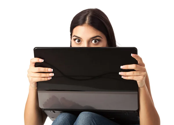 Jovem mulher bonita olhando sobre um laptop contra fundo branco — Fotografia de Stock