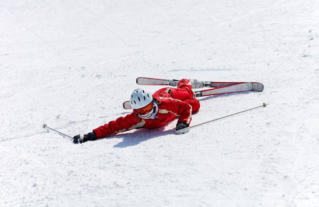 Female skier after falling down on a mountain slope