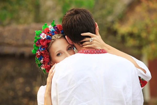 Jovem casal em trajes nacionais ucranianos abraçando ternamente — Fotografia de Stock