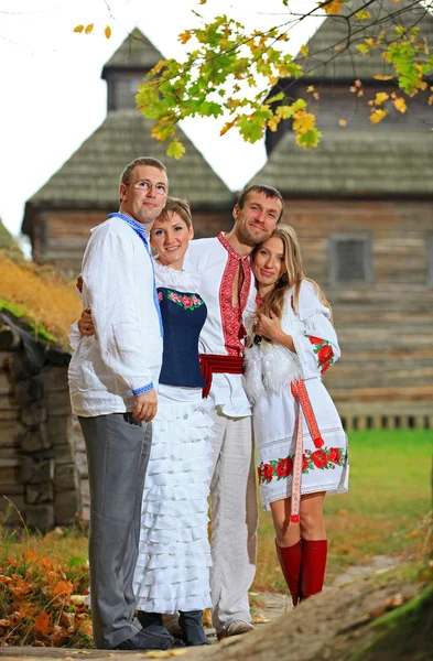 Två unga par i ukrainska stil kläder poserar utomhus — Stockfoto