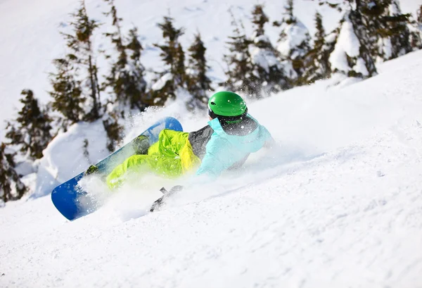 Unga manliga snowboardåkare efter faller på en berg-slutta — Stockfoto