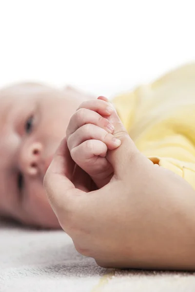 Baby boy holding mother's hand, image with shallow depth of field — Stock Photo, Image