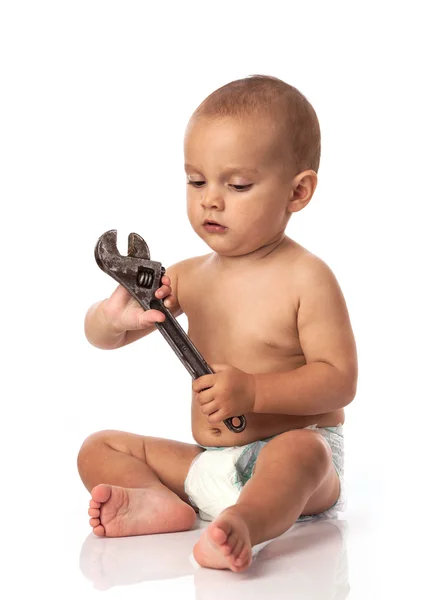 Söt liten pojke håller en justerbar skiftnyckel över vita — Stockfoto