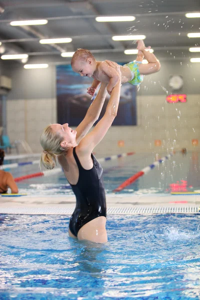 Ung mamma och Lille son ha kul i en pool, rörelse suddig bild — Stockfoto