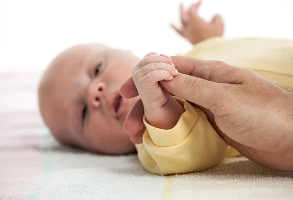 Babyjongen die vaders hand, afbeelding met ondiepe scherptediepte — Stockfoto