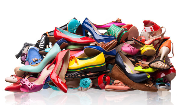 Pile of various female shoes over white