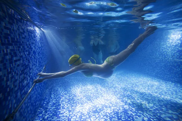 Genç hamile kadın sualtı yüzme havuzunda Telifsiz Stok Imajlar