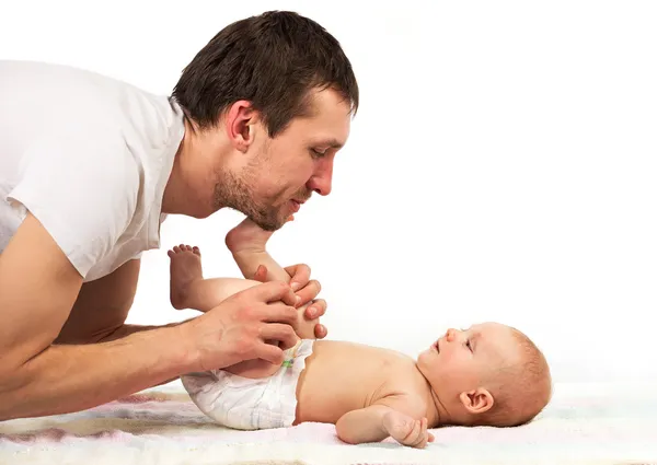 Jovem pai caucasiano brincando com o bebê filho sobre fundo branco — Fotografia de Stock