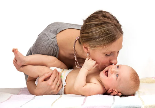 Jeune femme caucasienne embrasser son bébé fils sur fond blanc — Photo