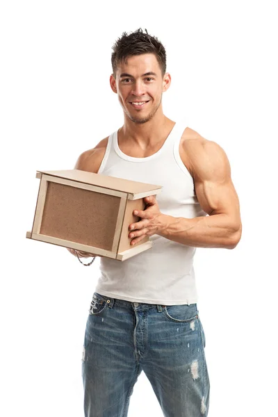 Musculoso joven sosteniendo parcela sobre fondo blanco — Foto de Stock