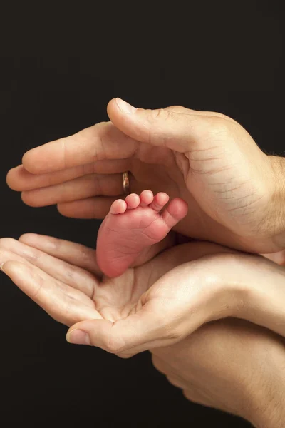 Νεογέννητο μωρό πόδι στους γονείς τα χέρια — Φωτογραφία Αρχείου