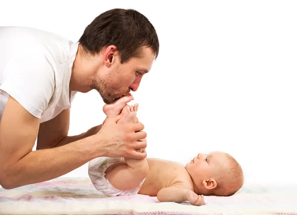 Young Caucasian father kissing feet of his baby son — Stock Photo, Image