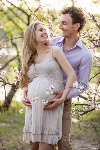 Jovem casal grávida ao ar livre na primavera — Fotografia de Stock