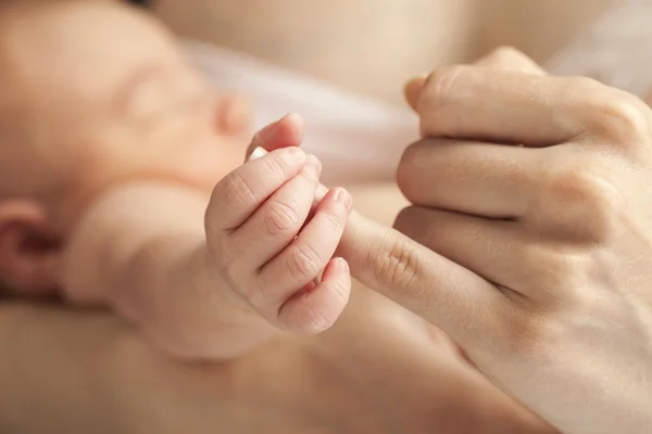 Neugeborenes Baby hält die Hand der Mutter, Bild mit geringer Schärfentiefe — Stockfoto