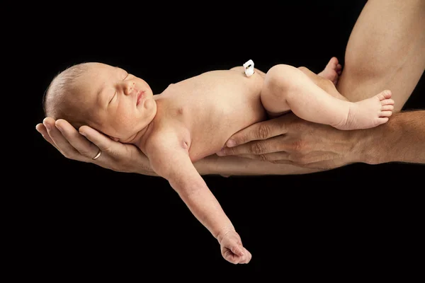 Un nouveau-né allongé sur les bras de son père — Photo