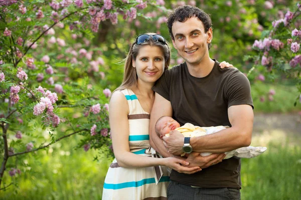 Genç çift yeni doğan oğlu ile açık havada bahar — Stok fotoğraf