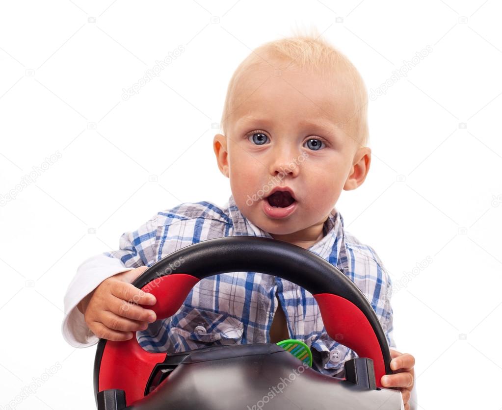 Little boy holding a toy steering wheel over white