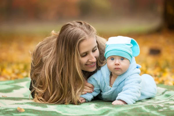 妇女抱着婴儿在片秋色的公园 — 图库照片