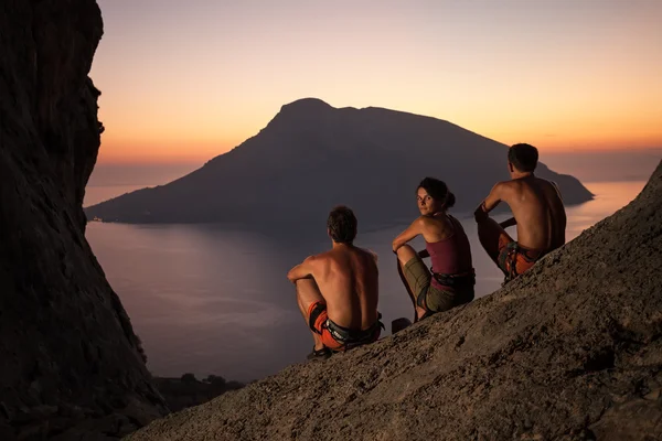 Three rock climbers having rest at sunset — Stock Photo, Image