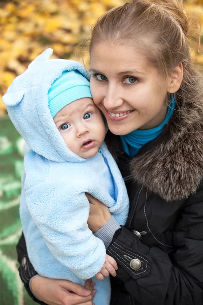 Mladá žena a její dítě syn v podzimním parku — Stock fotografie