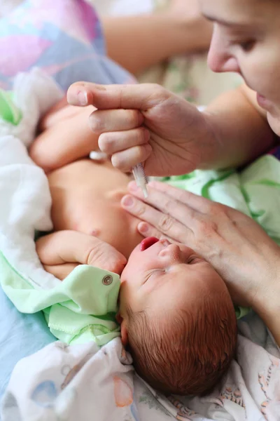 Mãe alimentando leite de bebê recém-nascido com seringa — Fotografia de Stock