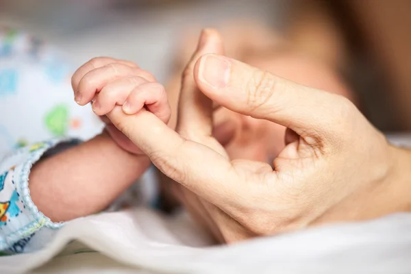 Новорожденный ребенок держит маму за руку — стоковое фото