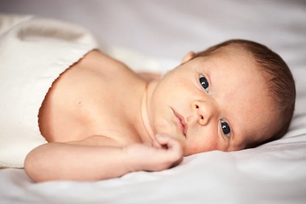 Милый новорожденный мальчик смотрит в камеру — стоковое фото