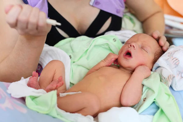 Mutter füttert Neugeborenes mit Spritze — Stockfoto