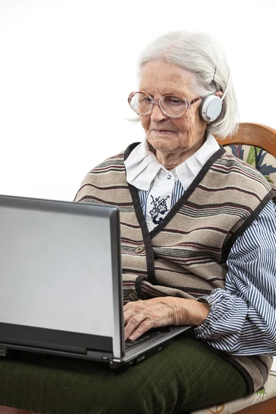 Donna anziana che utilizza il computer portatile su bianco — Foto Stock