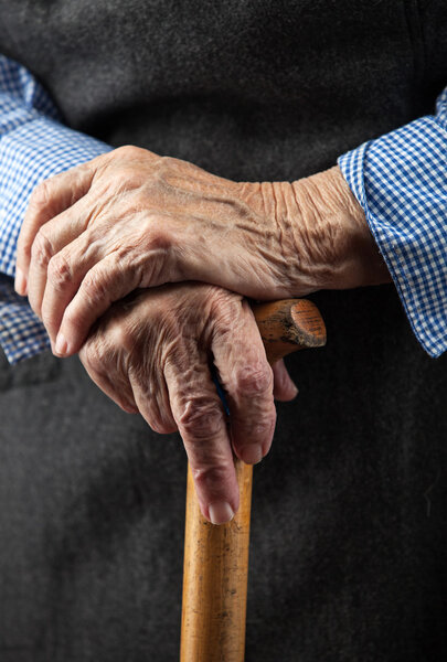 Closeup of senior woman's hands on walking stick