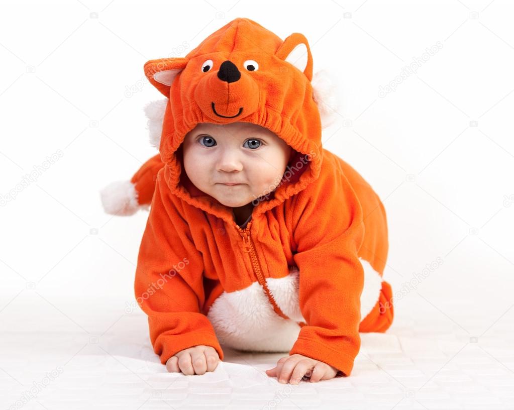 Baby boy in fox costume looking at camera on white