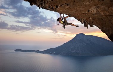 Young female rock climber at sunset