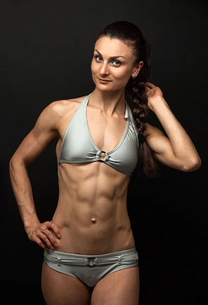 Young fitness woman posing over black — Stock Photo, Image