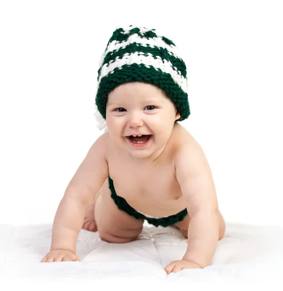 Niño feliz en sombrero de punto arrastrándose sobre blanco — Foto de Stock