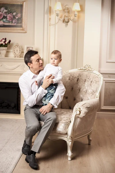 Young man with son sitting in living room — Stock Photo, Image