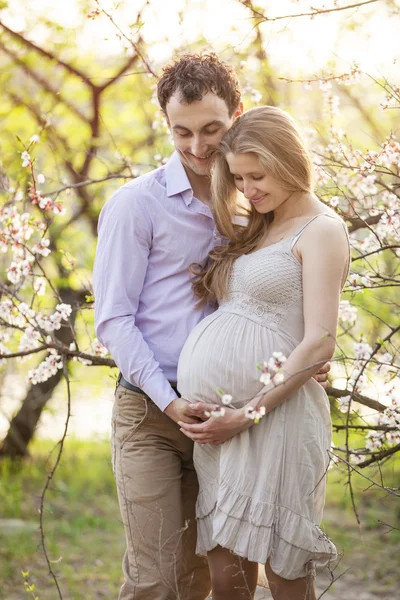 Joven pareja embarazada al aire libre en primavera —  Fotos de Stock