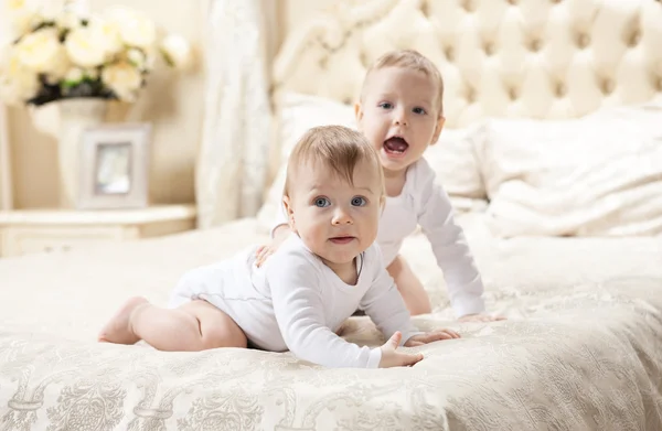 Två baby boys spelar på sängen — Stockfoto