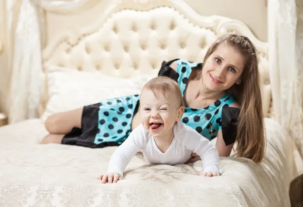 Mutter und kleiner Sohn amüsieren sich zu Hause im Bett — Stockfoto