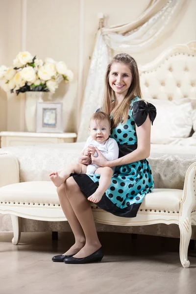 Žena s malým synem, sedí na gauči v ložnici — Stock fotografie