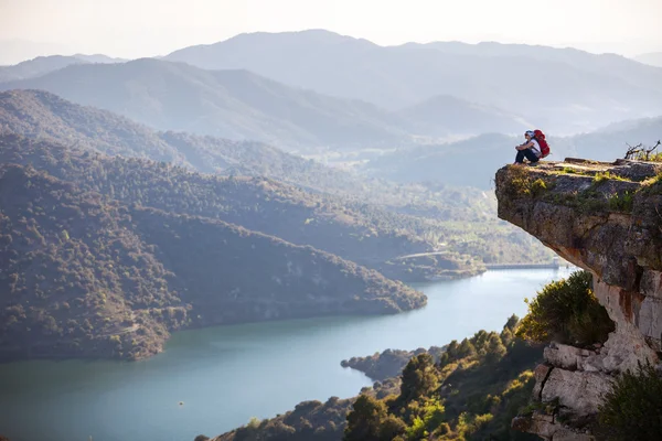 Senderista sentada en el acantilado y disfrutando de la vista del valle — Foto de Stock