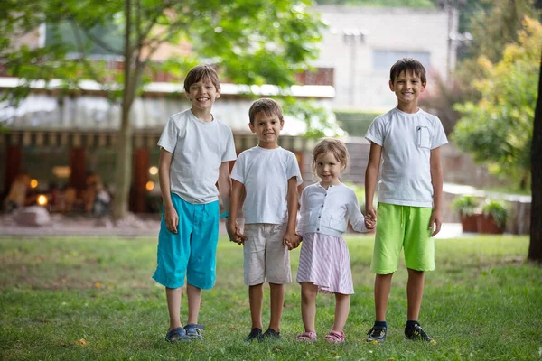 三个小男孩和一个小女孩在公园里 朋友或兄弟姐妹在户外玩耍 暑假的概念 — 图库照片