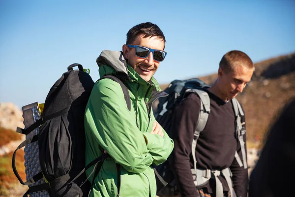 Two Men Backpacks Hiking Mountainous Area Man Green Jacket Looking — Fotografia de Stock