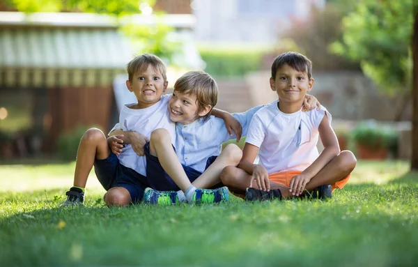 Tres Jóvenes Felices Parque Verano Amigos Hermanos Sentados Sobre Hierba — Foto de Stock