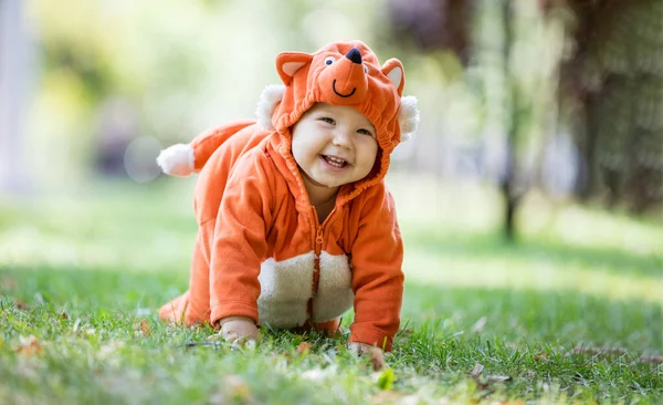 Roztomilá Usměvavá Holčička Oblečená Kostýmu Lišky Plazící Trávníku Parku — Stock fotografie