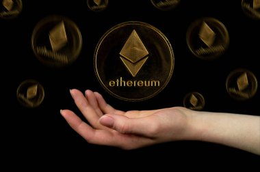 Ethereum kripto para biriminin elementleri ele düşer. Siyah arkaplanda fotoğraf
