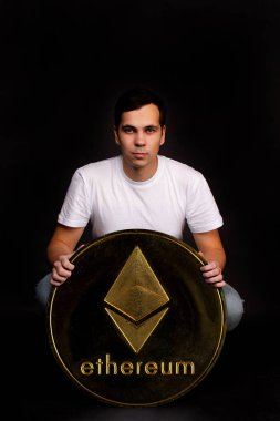 Genç bir adamda Bitcoin madeni parasının sembolü var. Değişim ve alım için modern bir para birimi.