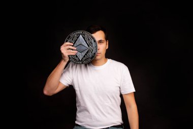 Elinde bozuk para olan bir adam arka planda klasik duruyor.