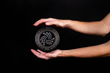 IOTA kripto para biriminin elementleri ele geçiyor. Siyah arkaplanda fotoğraf