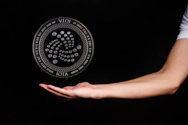 IOTA kripto para biriminin elementleri ele geçiyor. Siyah arkaplanda fotoğraf